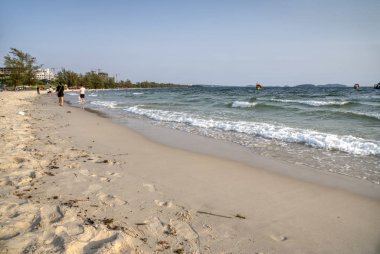Sihanoukville, Kamboçya. 26 Şubat 2019: Serendipity plajında güzel güneşli ve kumlu sahil boyunca yürüyen insanların sahnesi, Sihanoukville şehir.   