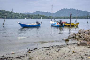 Perak, Malezya - 16 Şubat 2019: Kg Telaga Nenas, Ayer Tawar'da balık yakalamak için yüksek gelgit ya da balık avlamak için dışarı çıkmadığında deniz kenarında limanyapılan balıkçı teknelerinin sahnesi.