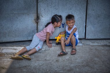 Sihanoukville, Kamboçya - 25 Şubat 2019: Sihanoukville balıkçı Köyü'ndeki evlerinin koridorunda oynayan kardeş ve erkek kardeş sahnesi