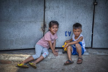 Sihanoukville, Kamboçya - 25 Şubat 2019: Sihanoukville balıkçı Köyü'ndeki evlerinin koridorunda oynayan kardeş ve erkek kardeş sahnesi