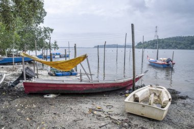 Perak, Malezya - 16 Şubat 2019: Kg Telaga Nenas, Ayer Tawar'da balık yakalamak için yüksek gelgit ya da balık avlamak için dışarı çıkmadığında deniz kenarında limanyapılan balıkçı teknelerinin sahnesi.