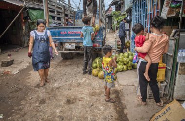 Sihanoukville, Kamboçya. Şubat 26, 2019: Sihanoukville Balıkçı Köyü'nde kamyondan hindistan cevizi meyvesi boşaltan erkeklerin sokak sahnesi.