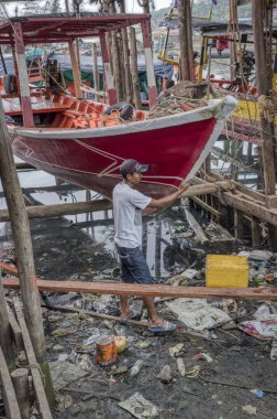 Sihanoukville, Kamboçya. 26 Şubat 2019 : Marangoz, Sihanoukville Balıkçı Köyü'nde tekneyi tamir etmek için yaptığı aletlerle ahşap işleri yapmakla meşgul.
