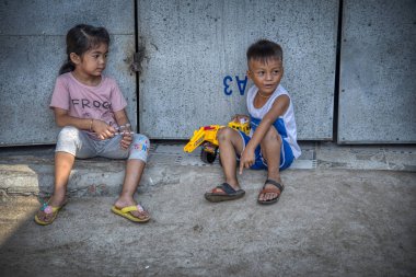 Sihanoukville, Kamboçya - 25 Şubat 2019: Sihanoukville balıkçı Köyü'ndeki evlerinin koridorunda oynayan kardeş ve erkek kardeş sahnesi