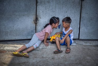 Sihanoukville, Kamboçya - 25 Şubat 2019: Sihanoukville balıkçı Köyü'ndeki evlerinin koridorunda oynayan kardeş ve erkek kardeş sahnesi