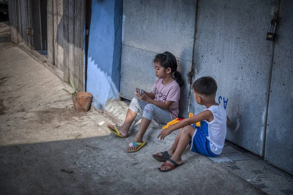 Sihanoukville, Kamboçya - 25 Şubat 2019: Sihanoukville balıkçı Köyü'ndeki evlerinin koridorunda oynayan kardeş ve erkek kardeş sahnesi