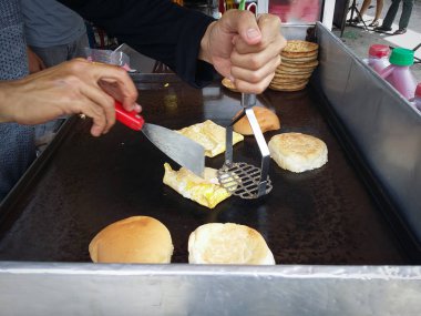 et ve yumurta burger hazırlayan tanınmayan biri