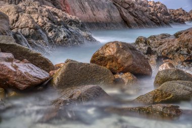 kayalık plaj etrafında hareket eden deniz dalgalarıyavaş deklanşör çekim