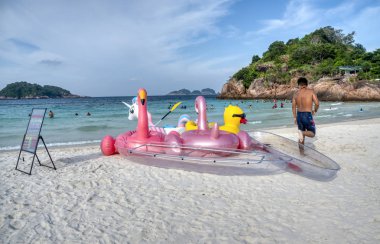 Trengganu, Malezya. 24 Haziran 2019 : Redang Adası sahil şeridinde çocuklar için yüzen oyuncaklar satan kişi veya satıcının sahnesi ve etkinliği. 