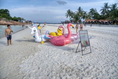 Trengganu, Malezya. 24 Haziran 2019 : Redang Adası sahil şeridinde çocuklar için yüzen oyuncaklar satan kişi veya satıcının sahnesi ve etkinliği. 