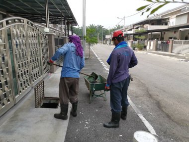 Perak, Malezya. 24 Ağustos 2019: Taman Pelangi Kampong Koh'daki yerleşim bölgesinin drenaj sistemini temizleyen iki Hintli belediye işçisinin sahnesi. 