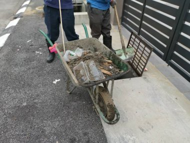 Perak, Malezya. 24 Ağustos 2019: Taman Pelangi Kampong Koh'daki yerleşim bölgesinin drenaj sistemini temizleyen iki Hintli belediye işçisinin sahnesi. 