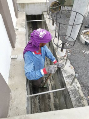 Perak, Malezya. 24 Ağustos 2019: Taman Pelangi Kampong Koh'daki yerleşim bölgesinin drenaj sistemini temizleyen iki Hintli belediye işçisinin sahnesi. 