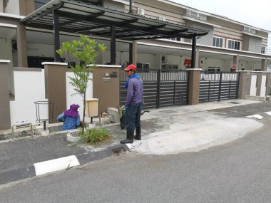 Perak, Malezya. 24 Ağustos 2019: Taman Pelangi Kampong Koh'daki yerleşim bölgesinin drenaj sistemini temizleyen iki Hintli belediye işçisinin sahnesi. 