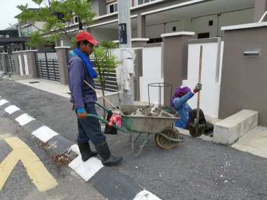 Perak, Malezya. 24 Ağustos 2019: Taman Pelangi Kampong Koh'daki yerleşim bölgesinin drenaj sistemini temizleyen iki Hintli belediye işçisinin sahnesi. 