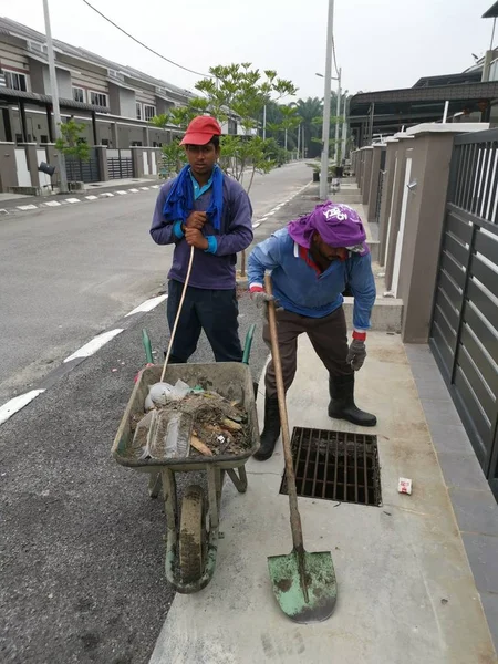 Perak, Malezya. 24 Ağustos 2019: Taman Pelangi Kampong Koh'daki yerleşim bölgesinin drenaj sistemini temizleyen iki Hintli belediye işçisinin sahnesi. 