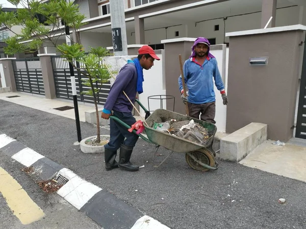 Perak, Malezya. 24 Ağustos 2019: Taman Pelangi Kampong Koh'daki yerleşim bölgesinin drenaj sistemini temizleyen iki Hintli belediye işçisinin sahnesi. 