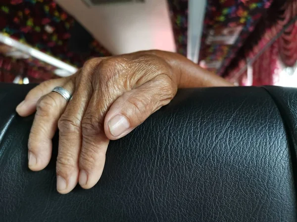 elderly hand resting on cushion