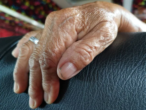 elderly hand resting on cushion