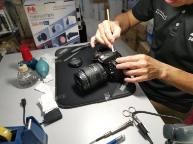 Perak, Malezya. 4 Ekim 2019: Aeon Sri Manjung Alışveriş Merkezi 'nde bulunan N4 Kamera Mağazası' nda Nikon kullanıcıları ve fotoğrafçıları için teknisyen temizlik DSR vücut sensörü ve lens.