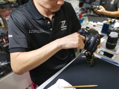 Perak, Malezya. 4 Ekim 2019: Aeon Sri Manjung Alışveriş Merkezi 'nde bulunan N4 Kamera Mağazası' nda Nikon kullanıcıları ve fotoğrafçıları için teknisyen temizlik DSR vücut sensörü ve lens.