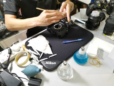 Perak, Malezya. 4 Ekim 2019: Aeon Sri Manjung Alışveriş Merkezi 'nde bulunan N4 Kamera Mağazası' nda Nikon kullanıcıları ve fotoğrafçıları için teknisyen temizlik DSR vücut sensörü ve lens.