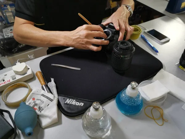 Perak, Malezya. 4 Ekim 2019: Aeon Sri Manjung Alışveriş Merkezi 'nde bulunan N4 Kamera Mağazası' nda Nikon kullanıcıları ve fotoğrafçıları için teknisyen temizlik DSR vücut sensörü ve lens.