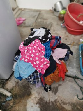 Bir kova dolusu kirli çamaşır çamaşır makinesinde yıkanmaya hazır.
