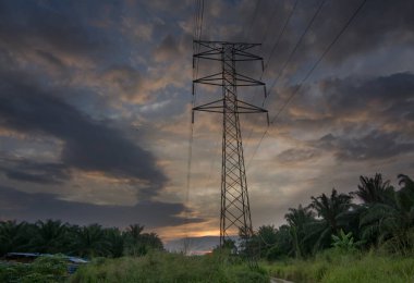 Elektrik kulesi yolunun kenarında güzel bir sabah güneşi doğuyor..