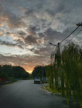 Perak, Malezya. 21 Haziran 2020: Taman Mas 1 Kg Koh yerleşim alanındaki sakin sabah sokağında güzel bir gündoğumu sahnesi.