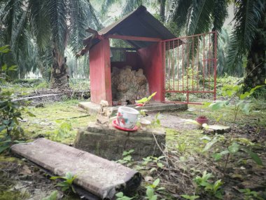 Perak, Malezya. 22 Haziran 2020: Kg Koh Palm Petrol Çiftliği 'ndeki toprak tanrısına saygı göstermek için çiftlik içine beton minyatür sunak inşa edildi.