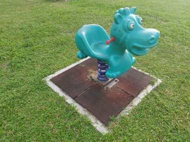 Çocuk parkında bahar binicisi oyuncağı sallanıyor.