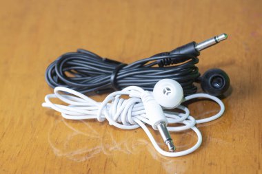 Siyah ve beyaz kablolu tek çizgi kulak tıkacının yakın çekimi.