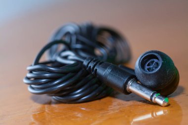 Yakın çekim siyah kablolu tek çizgi kulak tıkacı.