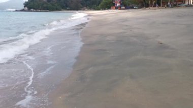 Gündüz sahnesi deniz yükseldiğinde kumlu kumsalda dalgalar hareket ederken