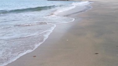 Gündüz sahnesi deniz yükseldiğinde kumlu kumsalda dalgalar hareket ederken