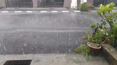Verandanın dışında şiddetli yağmur yağışının görüntüleri.