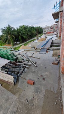 Bitmemiş inşaat binasının etrafında toplanan durgun yağmur suyu havuzu.