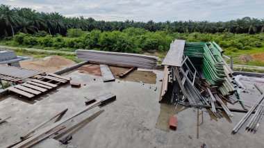 Bitmemiş inşaat binasının etrafında toplanan durgun yağmur suyu havuzu.