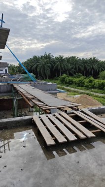 Bitmemiş inşaat binasının etrafında toplanan durgun yağmur suyu havuzu.