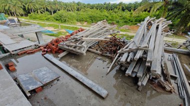 Bitmemiş inşaat binasının etrafında toplanan durgun yağmur suyu havuzu.