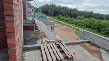 Bitmemiş inşaat binasının etrafında toplanan durgun yağmur suyu havuzu.