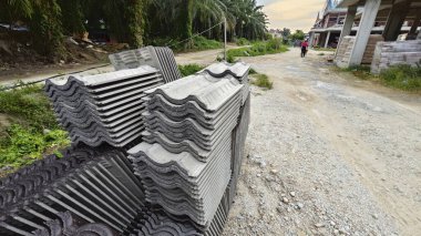 İnşaat alanının dışında yeni koyu kahverengi çatı döşemeleri var..