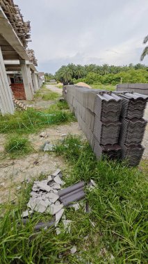 İnşaat alanının dışında yeni koyu kahverengi çatı döşemeleri var..