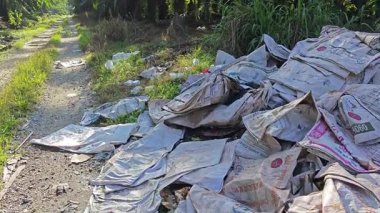 Perak, Malezya. 15 Eylül 2025: KgKoh çiftliğindeki izole hurdalıkta bulunan polipropilen tahıl çuvalları yığını.