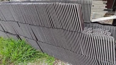 piles of new black rooftiles laying outside the construction site.