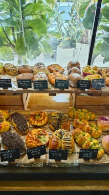 Perak, Malaysia. September 18, 2025: Varieties of bread, pastry and cake on display and sale in the glass shelves at the Noah's Roastry cafe,Sitiawan.