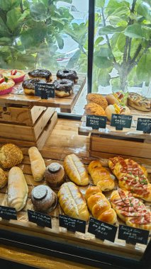 Perak, Malaysia. September 18, 2025: Varieties of bread, pastry and cake on display and sale in the glass shelves at the Noah's Roastry cafe,Sitiawan.