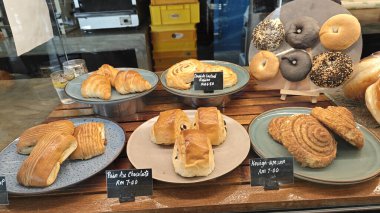 Perak, Malaysia. September 18, 2025: Varieties of bread, pastry and cake on display and sale in the glass shelves at the Noah's Roastry cafe,Sitiawan.