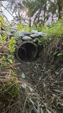 Basit kırsal kanal sulama ve drenaj sistemi. Palmiye yağı tarlalarında taş yığını var..